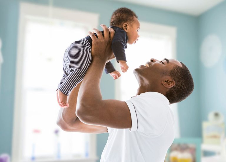 A father holding his child in a nursery