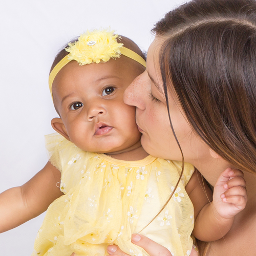 Mom kissing baby Kaia's cheek
