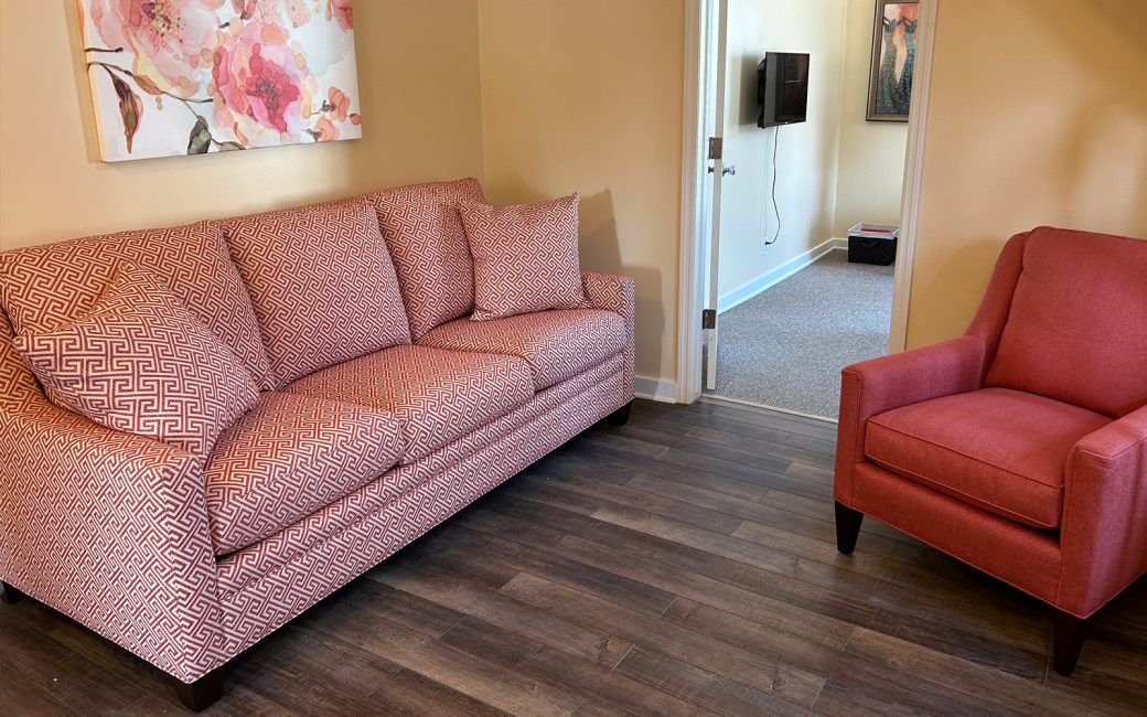 counseling room with pattern pink couch and solid pink chair