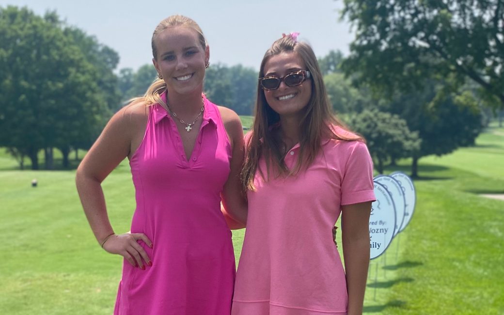 Two women dressed in pink on golf course