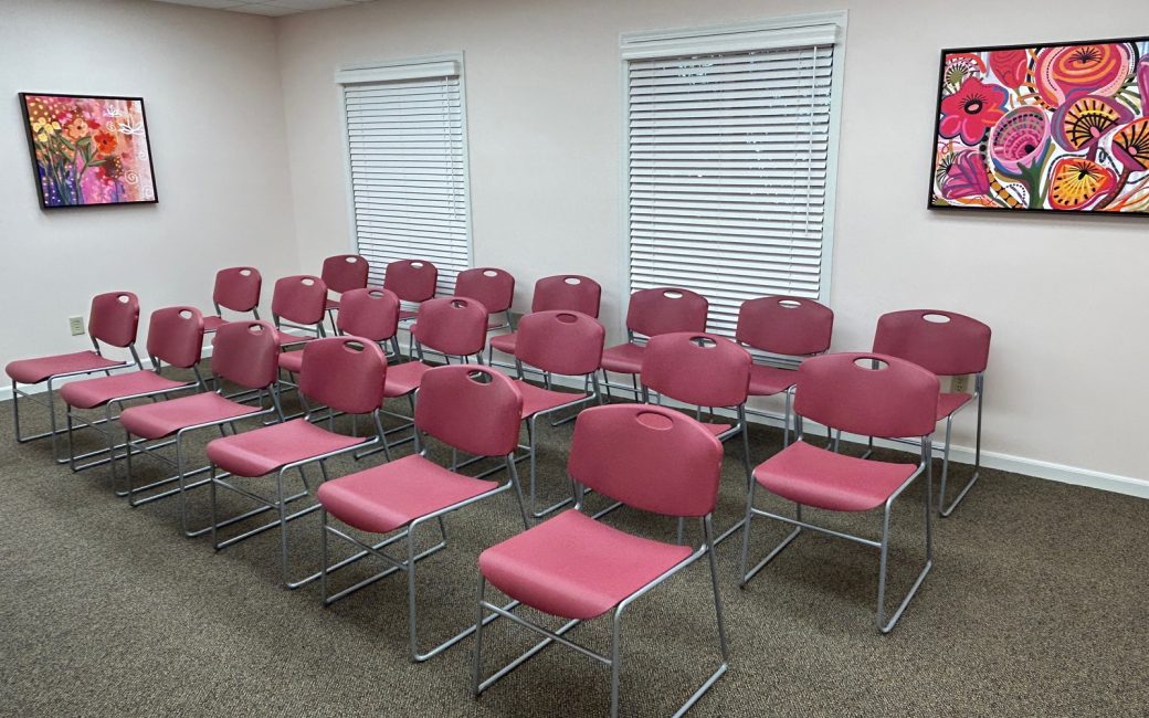 classroom with pink chairs lined up in rows